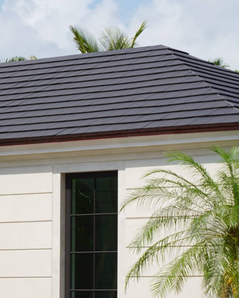 Modern Roof Style Modern home with smooth flat gray clay roof tiles and white stucco exterior.