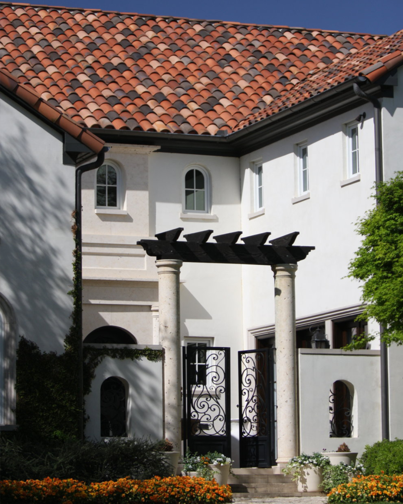 Spanish & Mediterranean Roof Style Spanish Mediterranean-style home with red clay barrel roof tiles and white stucco walls.